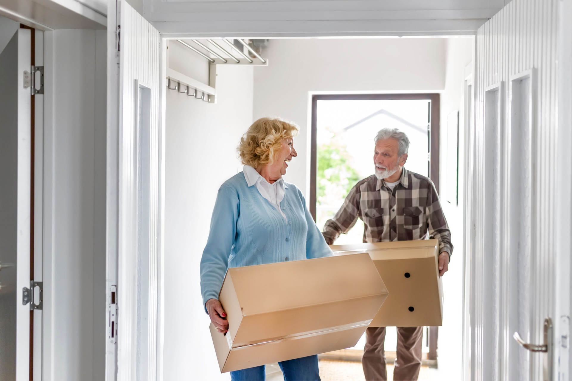 Senior couple carrying boxes