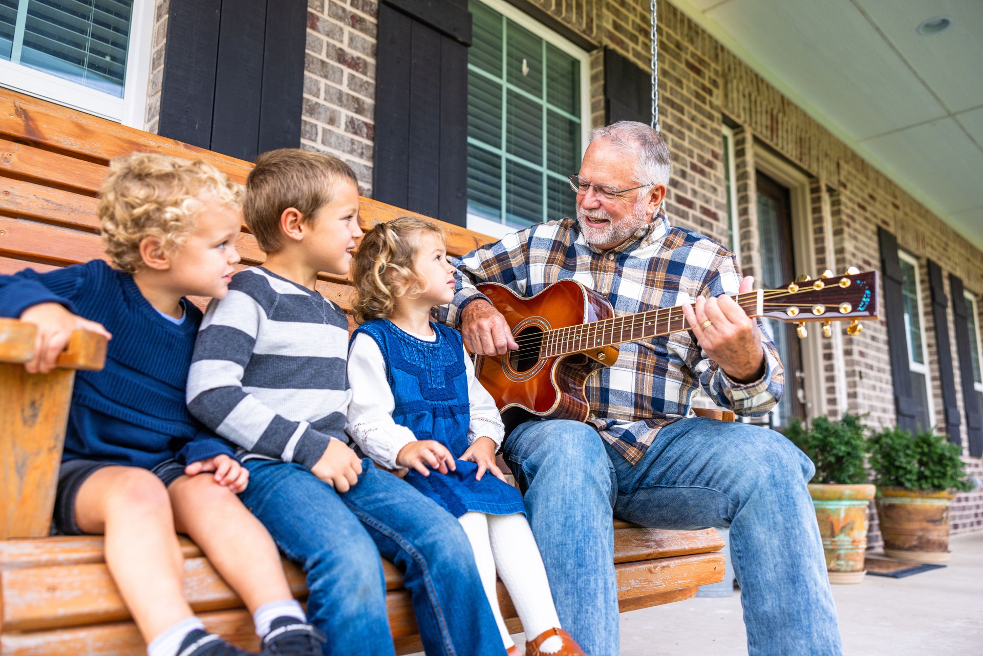 Grandfather playing guitar singing with his grandchildren