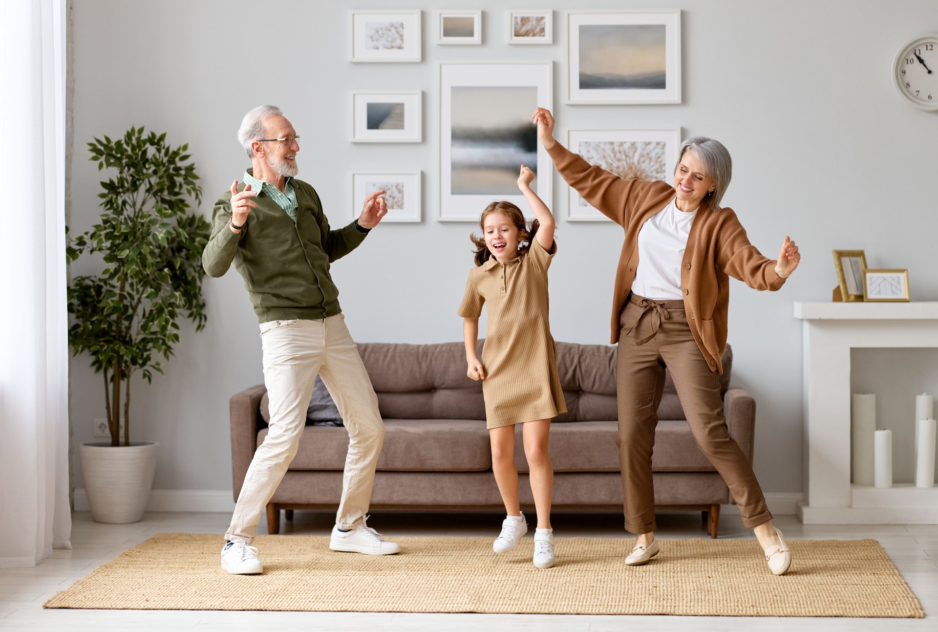 Excited preschool girl having fun with active positive grandpare